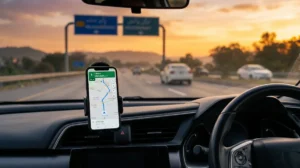 Car dashboard with smartphone displaying live GPS route along Pakistan motorway