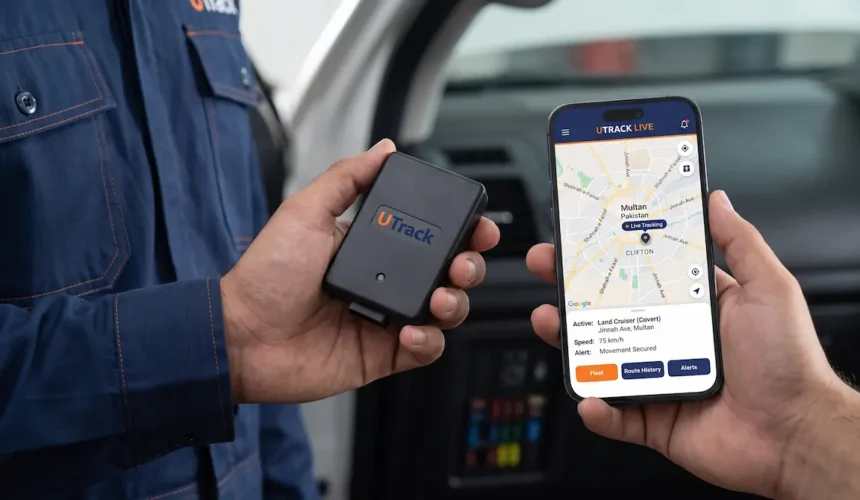 Technician in Multan holding a covert GPS tracker, comparing the UTrack live fleet management app to Tracking World.